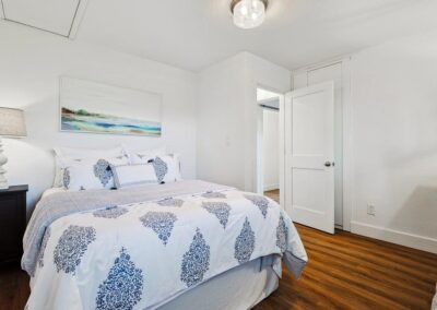 Secondary bedroom with queen bed, soft bedding, and clean-fresh decor