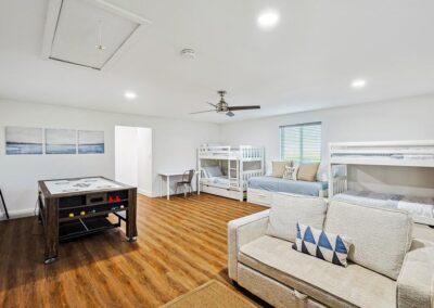 Entertainment room with pool, ping pong, air hockey, games, several bunk beds and a relaxed hangout space