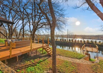 Back view of The Granbury Getaway vacation home with clean landscaping and a great deck for sunset views